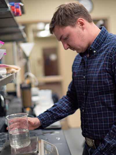 A student works with a glass beaker in 工程 class